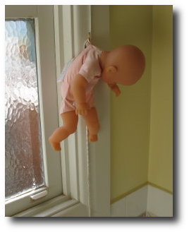 Baby drying on hook. Not real baby. Doll baby.